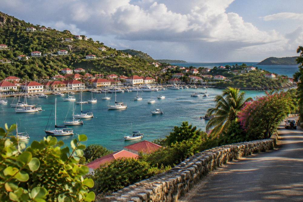 A quiet hillside road above the coast of St Barts with red rooftops in the distance