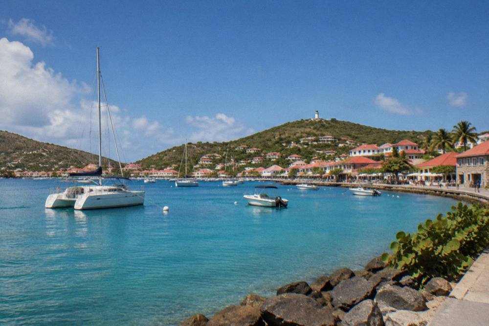 A catamaran moored in a quiet bay with hills behind