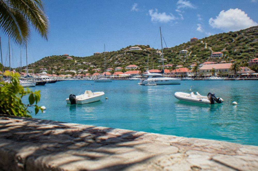 Red-roofed houses on a green hillside overlooking the sea in St Barts
