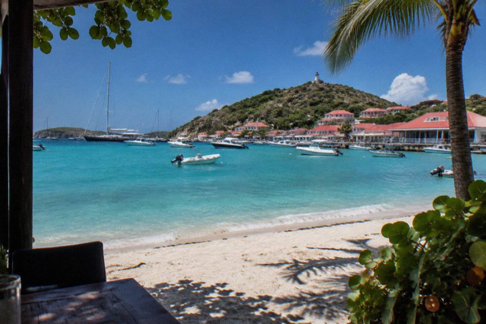 A palm-fringed white sand beach on a calm sunny morning in the Caribbean