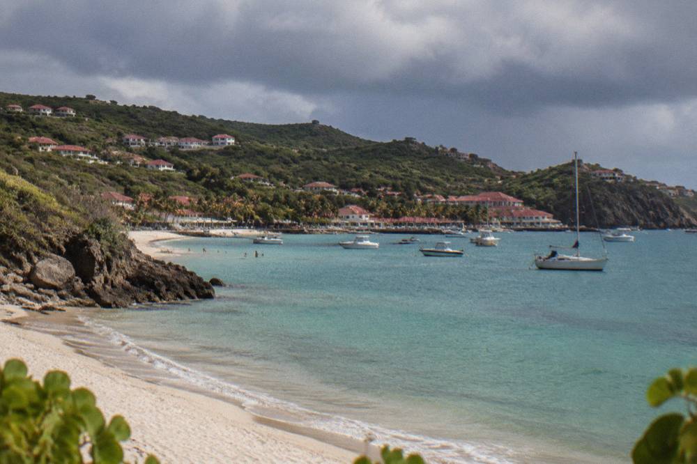 Dark rain clouds gathering over the hills of a small Caribbean island seen from the sea