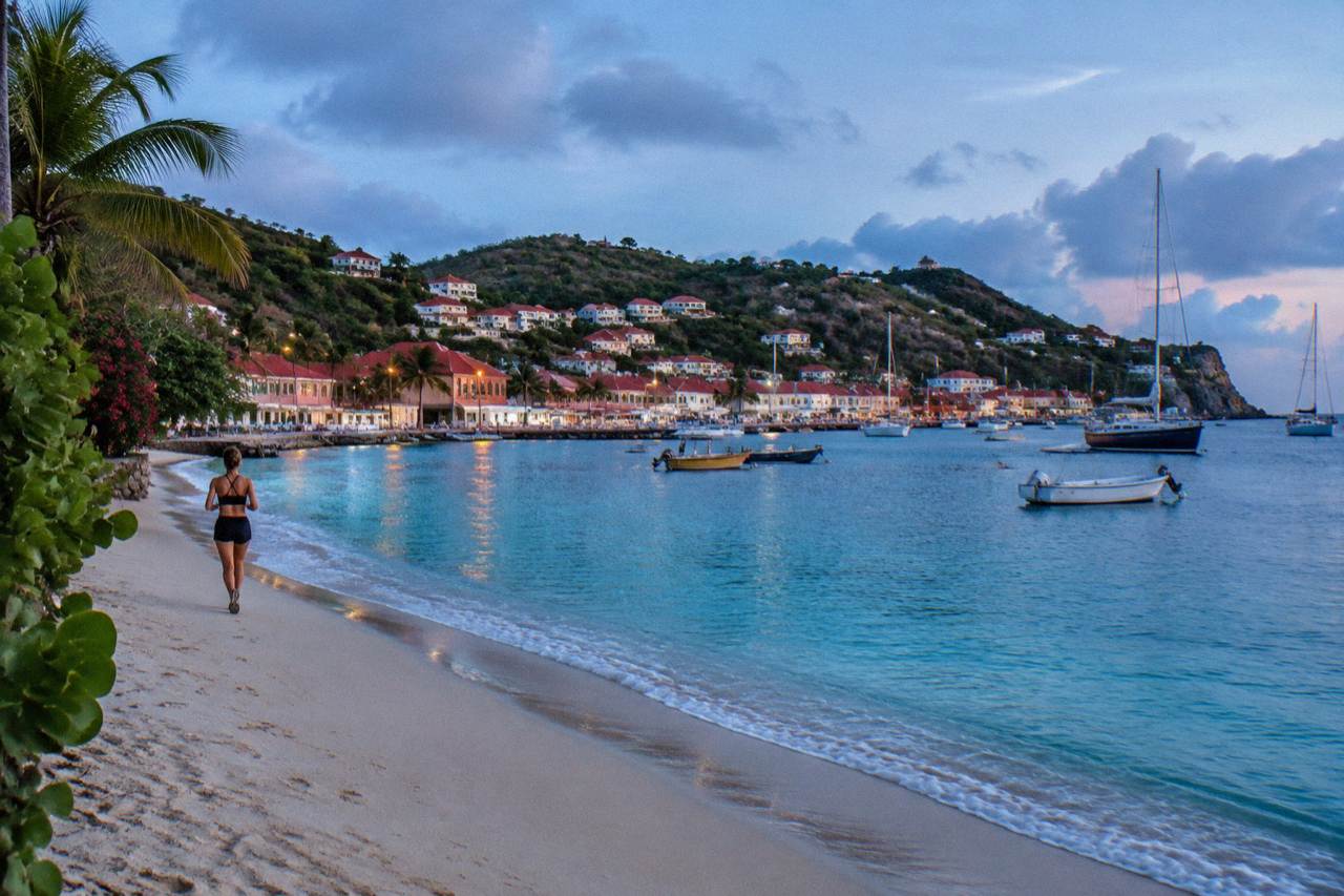 An empty curve of sand beside calm turquoise water on a quiet Caribbean morning