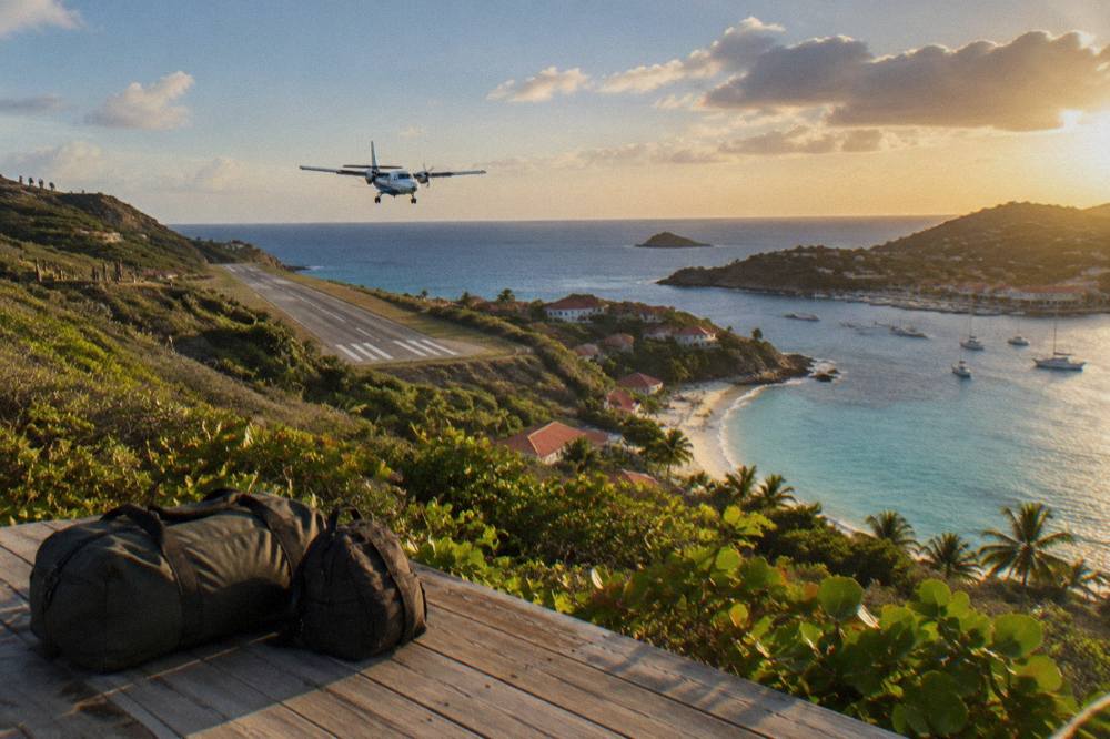 A duffel bag and small backpack packed for a tropical island trip on a wooden floor