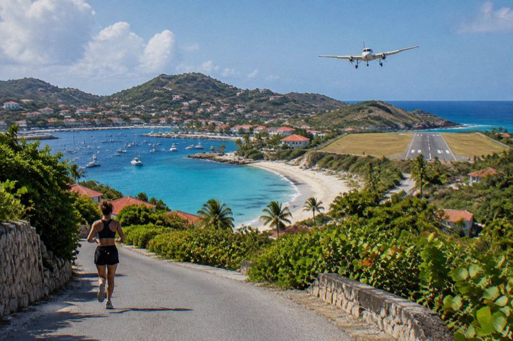 A narrow hillside road on a small Caribbean island winding down toward a harbor