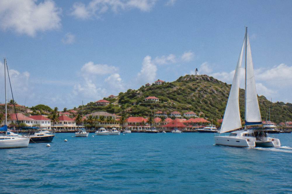 A sailing catamaran underway on open Caribbean water in morning light