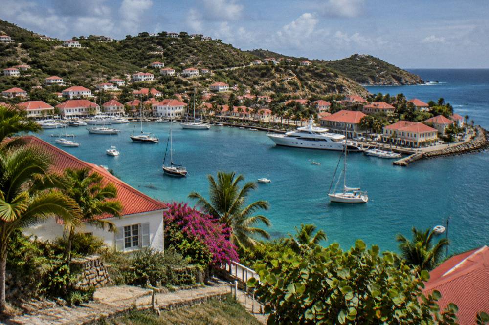 White cottages with red roofs on a hillside above a Caribbean bay