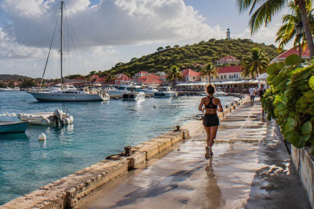 Yachts and small boats anchored in a harbour with red rooftops rising behind them