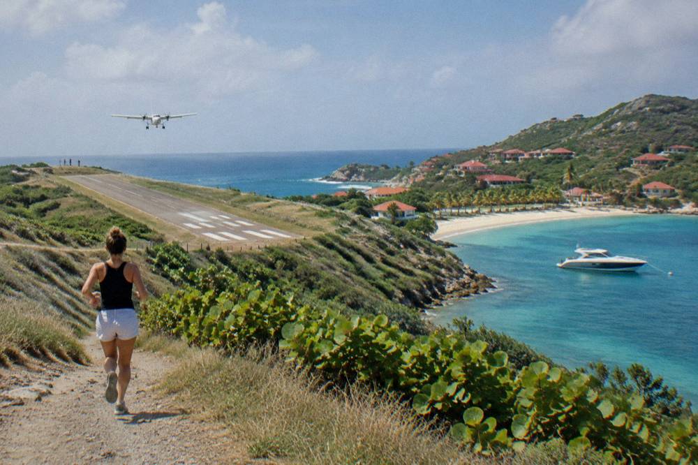 A sleek private charter boat moored in a calm Caribbean bay near a sandy beach