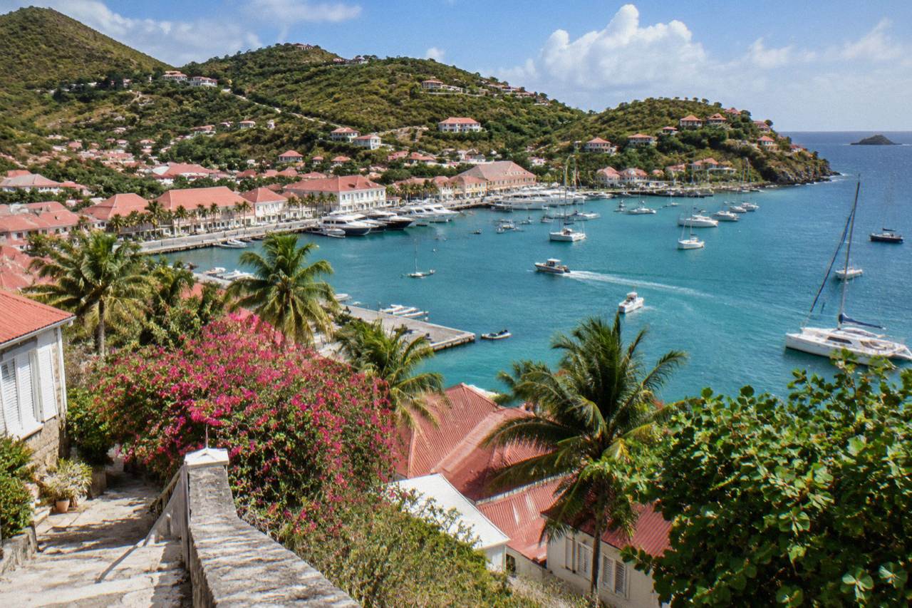 Hillside villas with red roofs above a turquoise bay on a Caribbean island