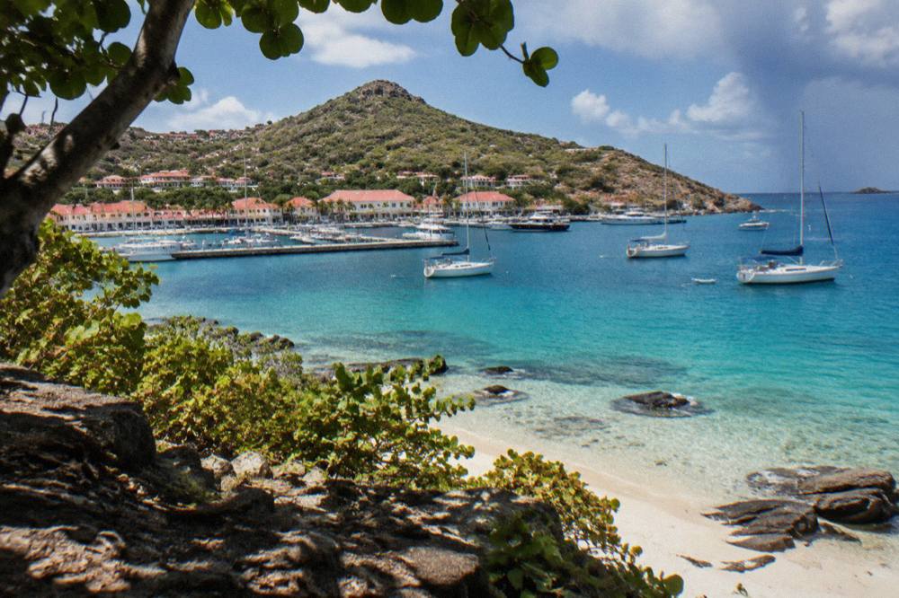 A harbor town with white buildings and boats moored along a stone quay