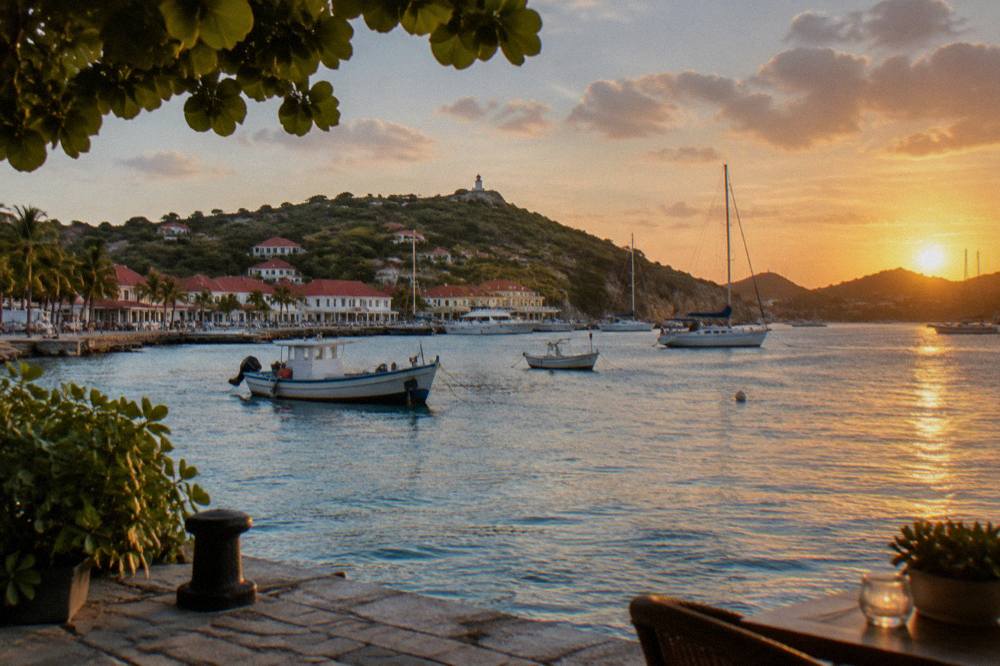 Sunset light over Gustavia harbor in St Barts with fishing boats and hills