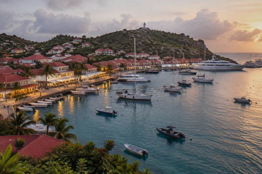 Evening light over Gustavia harbor with boats and lit shopfronts