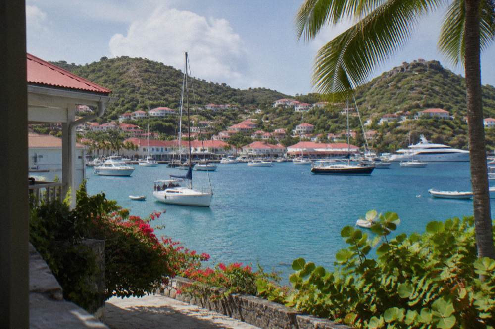 Red-roofed houses above the harbour in Gustavia, St Barts, with yachts moored in the bay