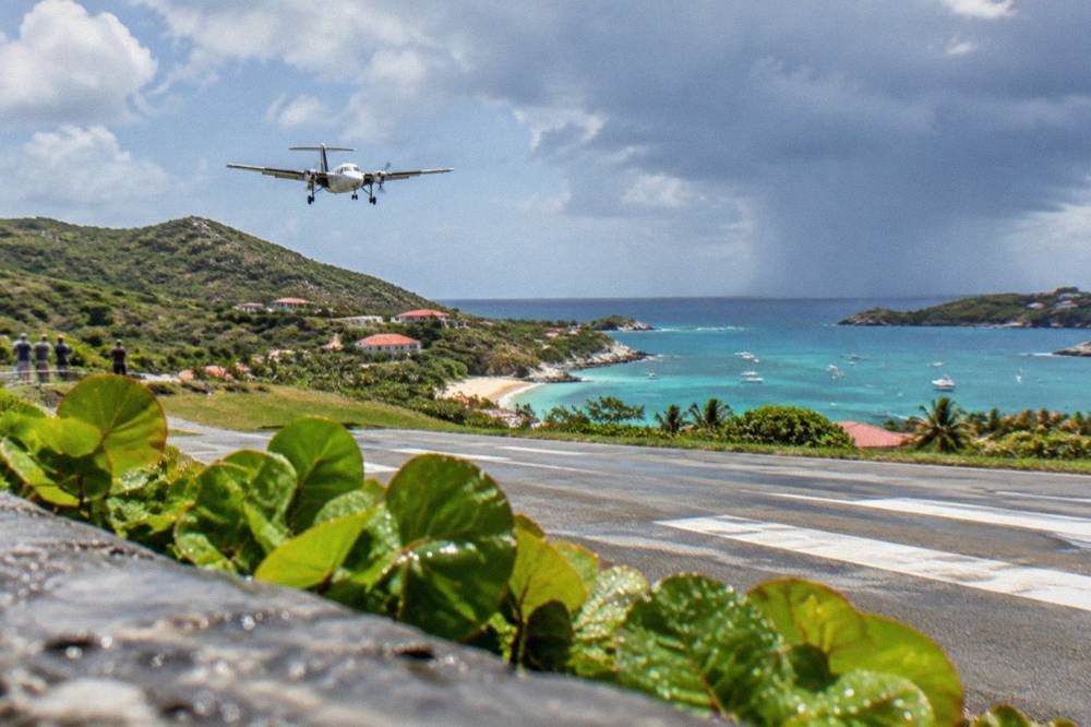 A small turboprop aircraft on the short runway at Gustaf III airport in St Barts
