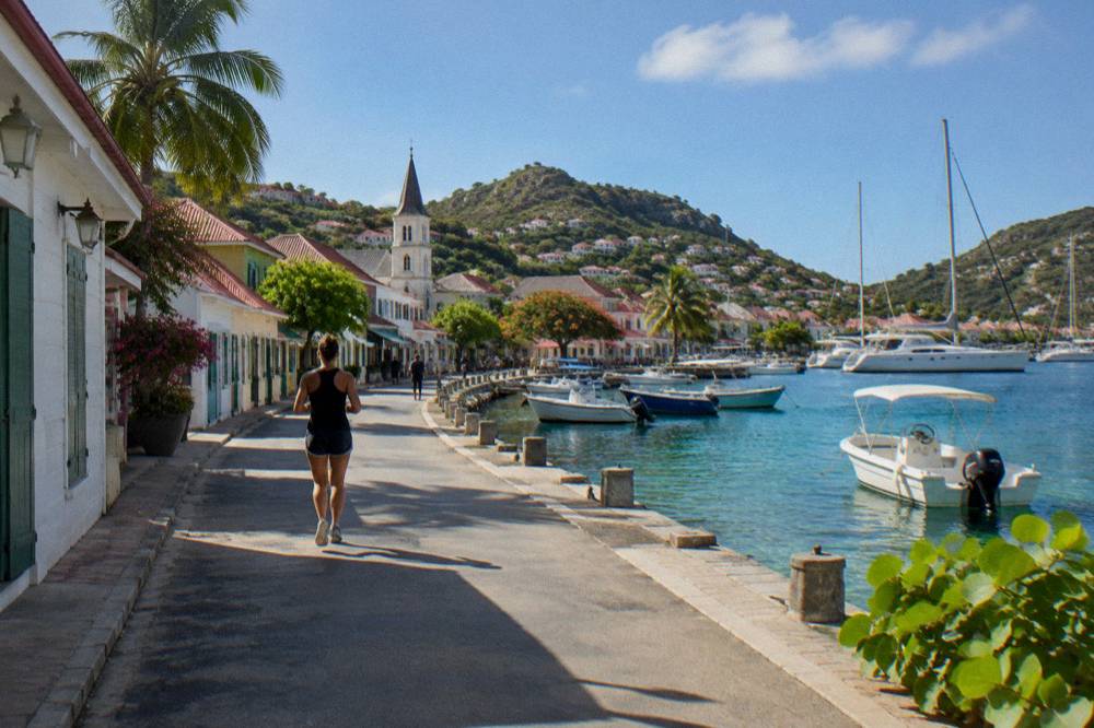A quiet street in Gustavia with shops and a church tower under a blue sky