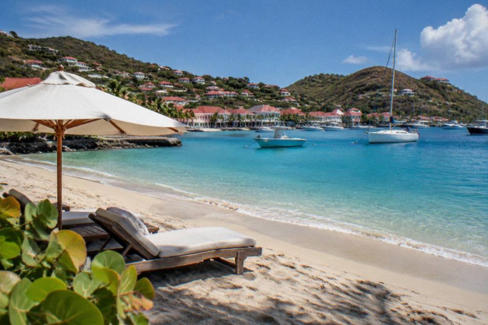 Sun loungers and an umbrella on a quiet sandy beach in St Barts