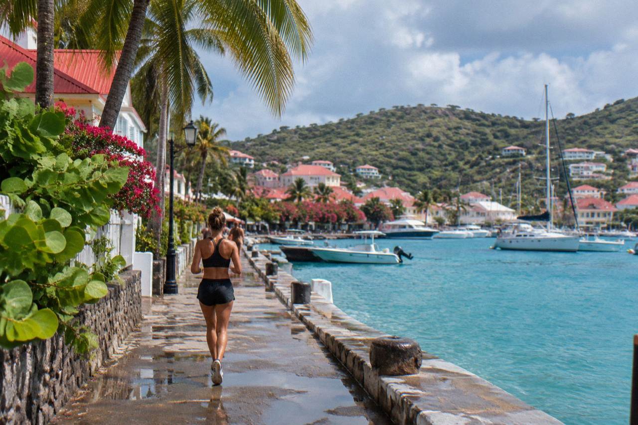 Sailboats anchored in turquoise water below the hills of St Barts