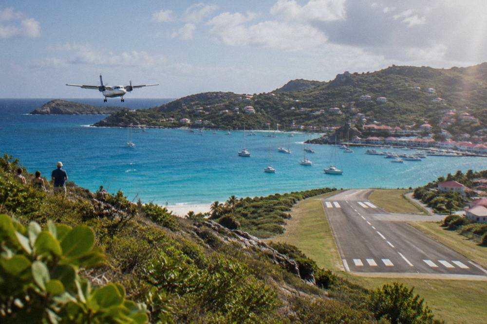 A small turboprop aircraft on the short runway at Gustaf III Airport in St Barts