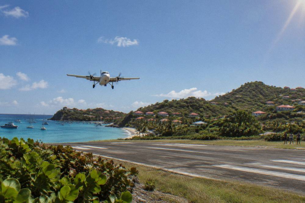 A small turboprop aircraft on the short runway at Gustaf III airport in St Barts