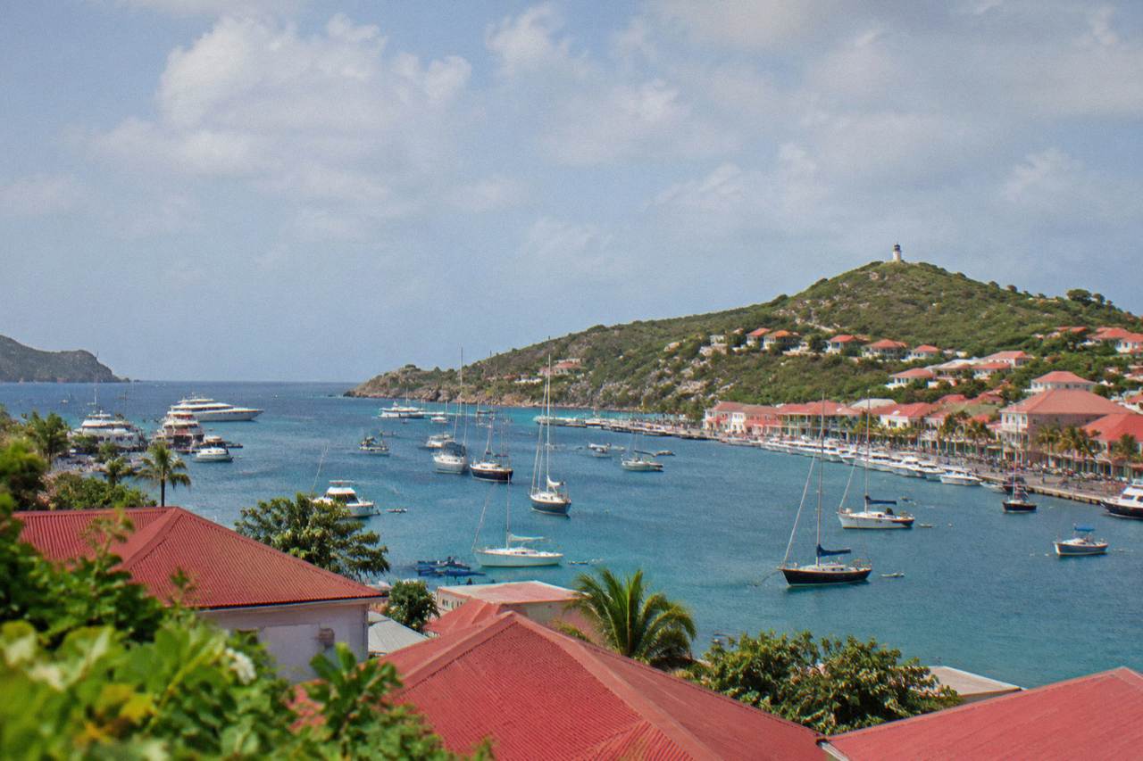 A view over red rooftops and sailboats in Gustavia harbor on St Barts