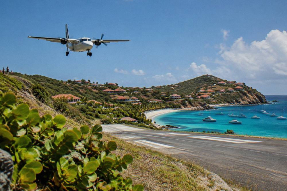 A small turboprop aircraft on the short runway at Gustaf III Airport in St Barts