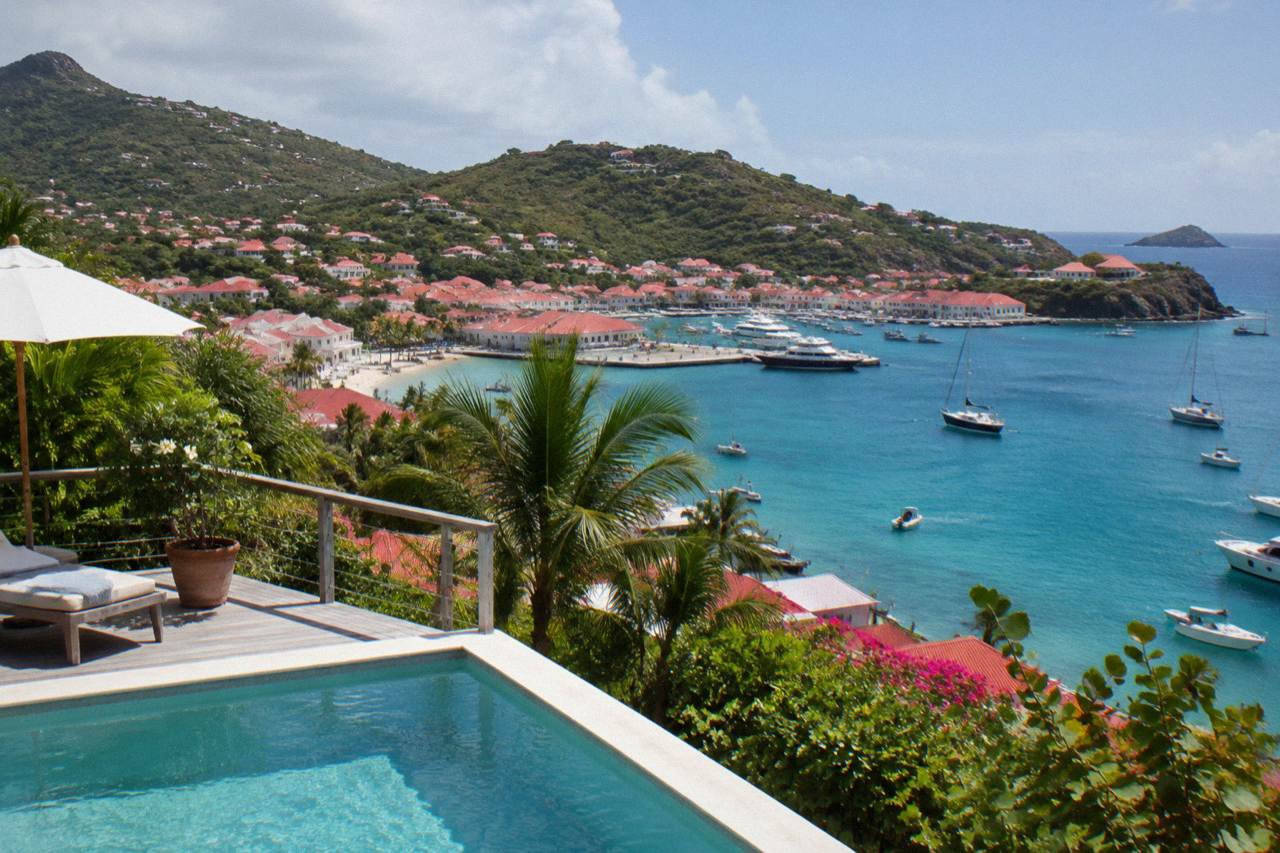 A hillside villa with a terrace pool overlooking a turquoise Caribbean bay