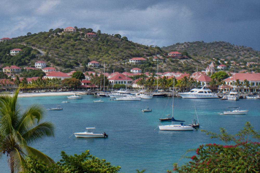 Red roofs of villas on a green hillside above a Caribbean bay