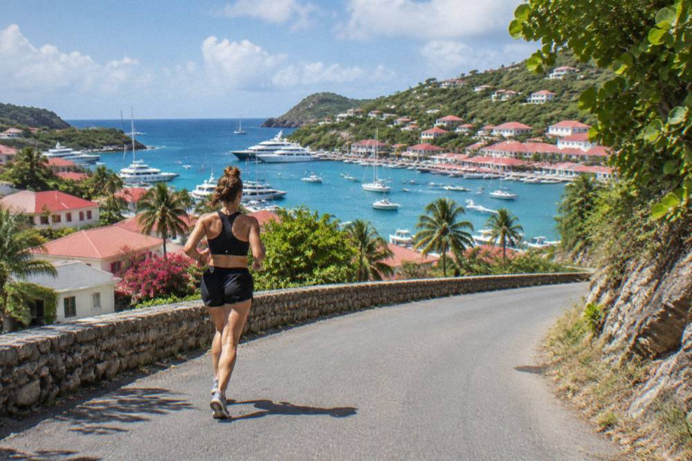 A narrow winding road climbing a green hill with sea views