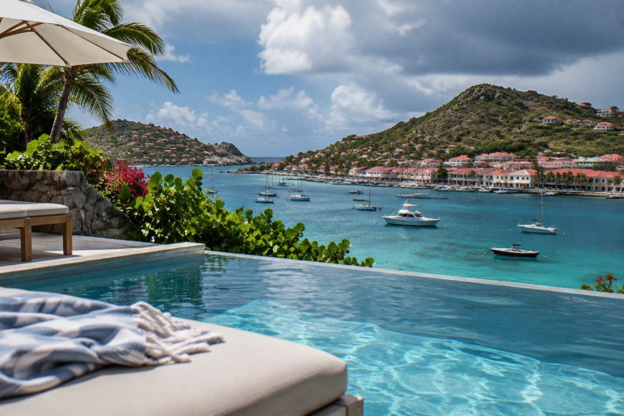 A private villa pool terrace above the turquoise water of a Caribbean island