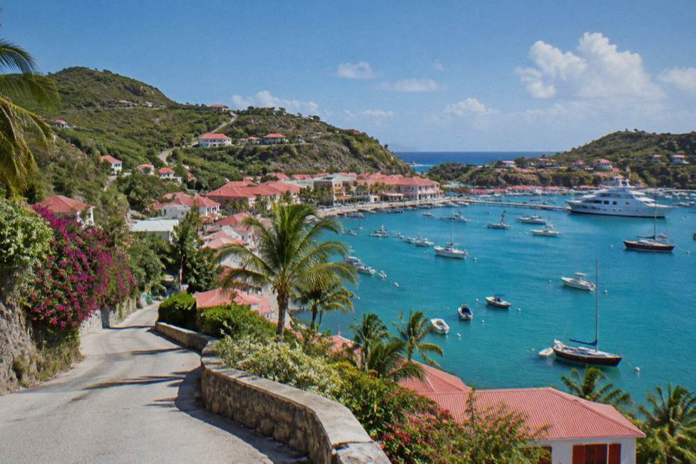 A narrow winding island road with sea views between hills on St Barts