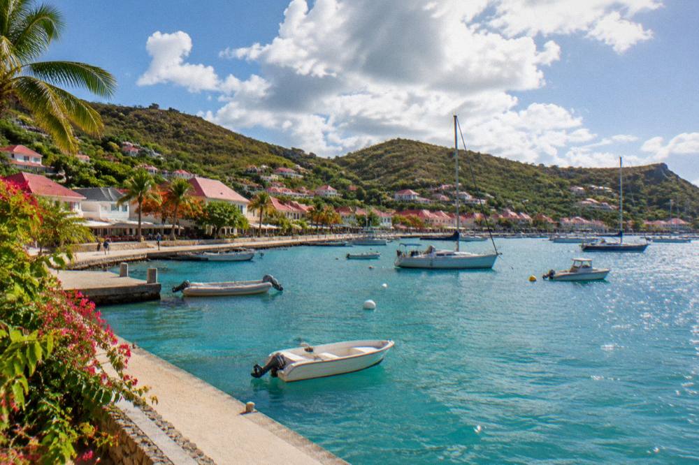 Sun breaking through clouds over the harbour of Gustavia with boats at anchor