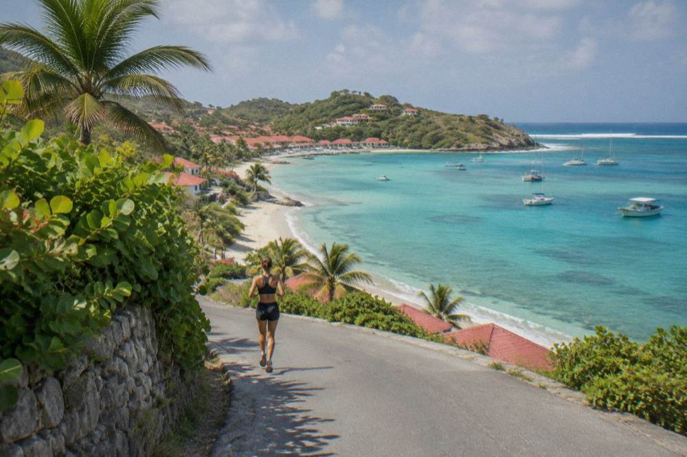 A narrow winding island road with green hills and a glimpse of turquoise sea below