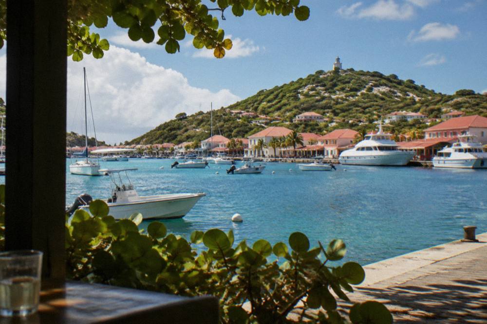 White ferry boats moored at a Caribbean marina with hills behind