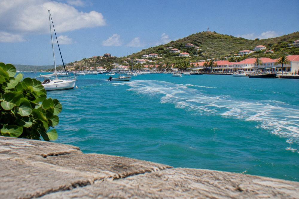 A ferry wake trailing across turquoise Caribbean water at midday