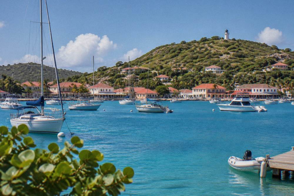 A curved Caribbean bay with turquoise water and green headlands