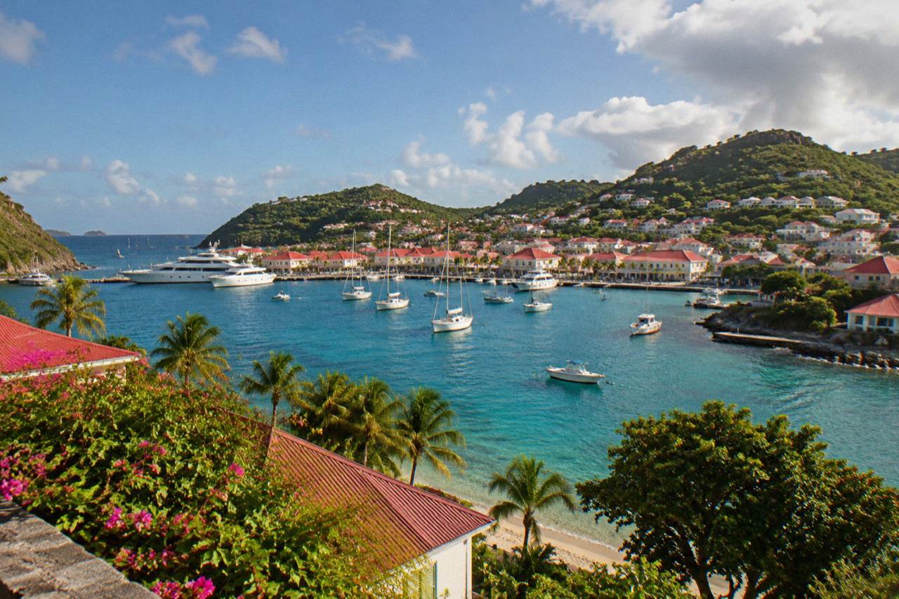 Aerial view of a green Caribbean island with turquoise water and a small harbor town