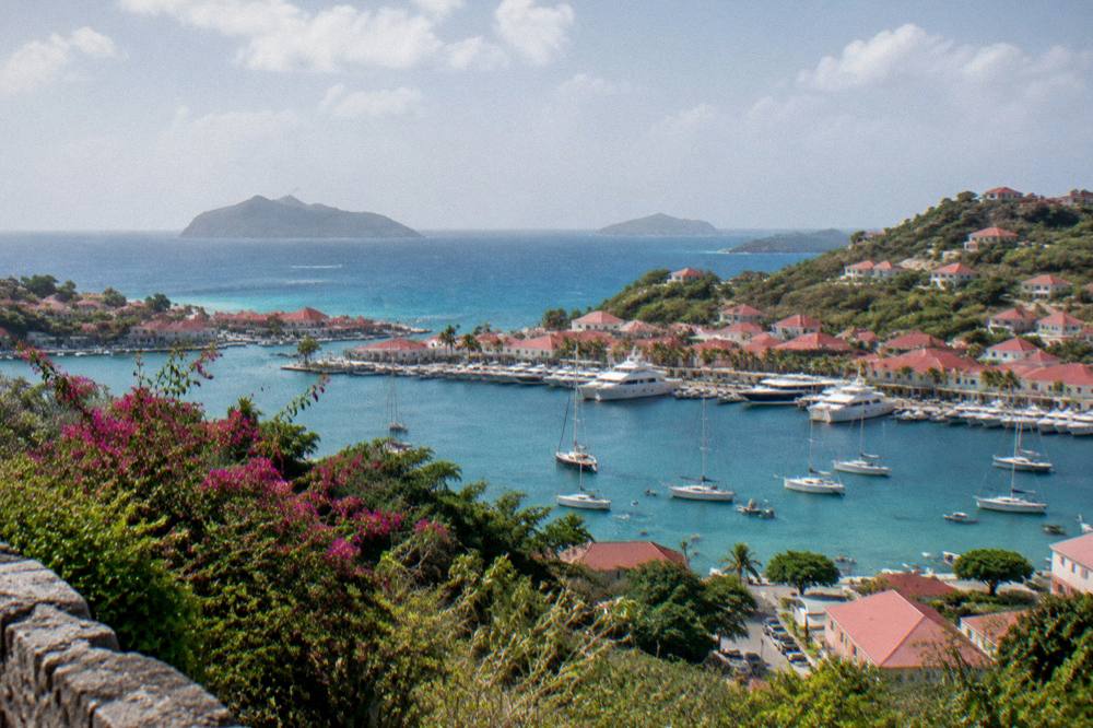 Two Caribbean islands seen across open water from a green headland