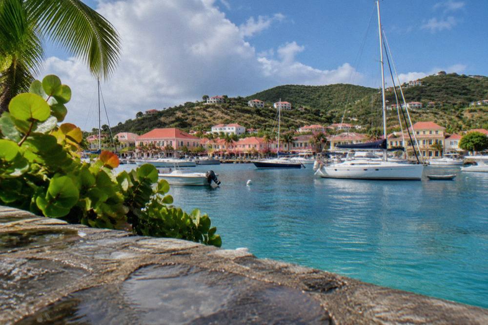 Yachts moored in the harbour of Gustavia with pastel buildings along the waterfront