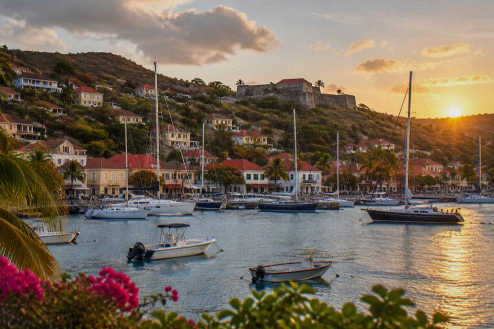 Stone fortification walls above a harbor with masts and small boats below