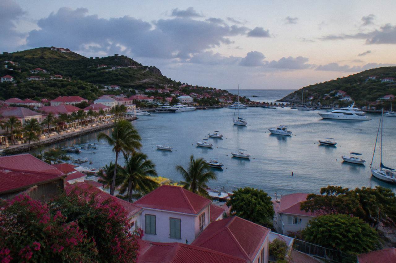 A view over red rooftops and boats anchored in a Caribbean harbour