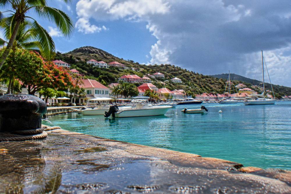 White houses with red roofs along a hillside above a small harbour