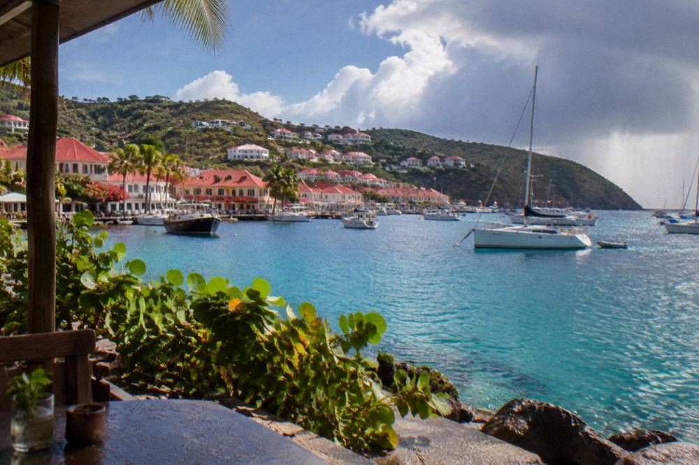 White hillside villas with red roofs terraced above a bay at dusk
