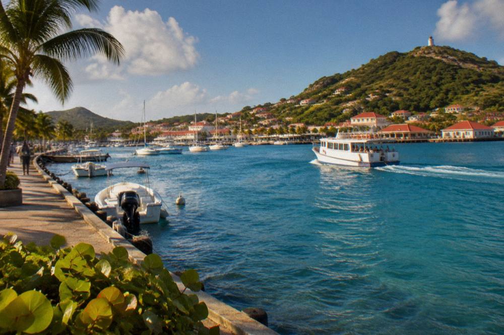 Ferry boat leaving Gustavia harbour with hills behind under an open sky on St Barts