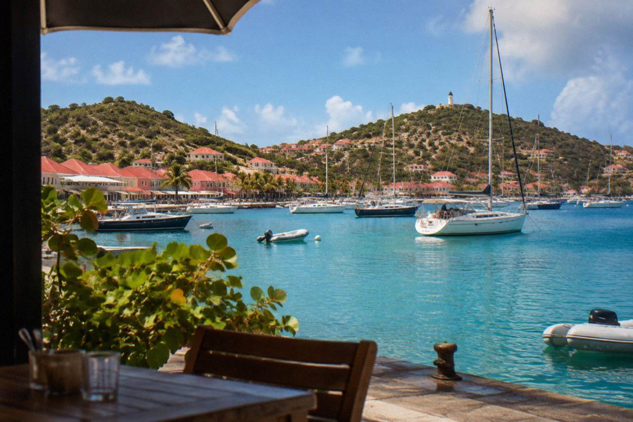Sailboats anchored in turquoise water below the hills of Gustavia harbour on St Barts
