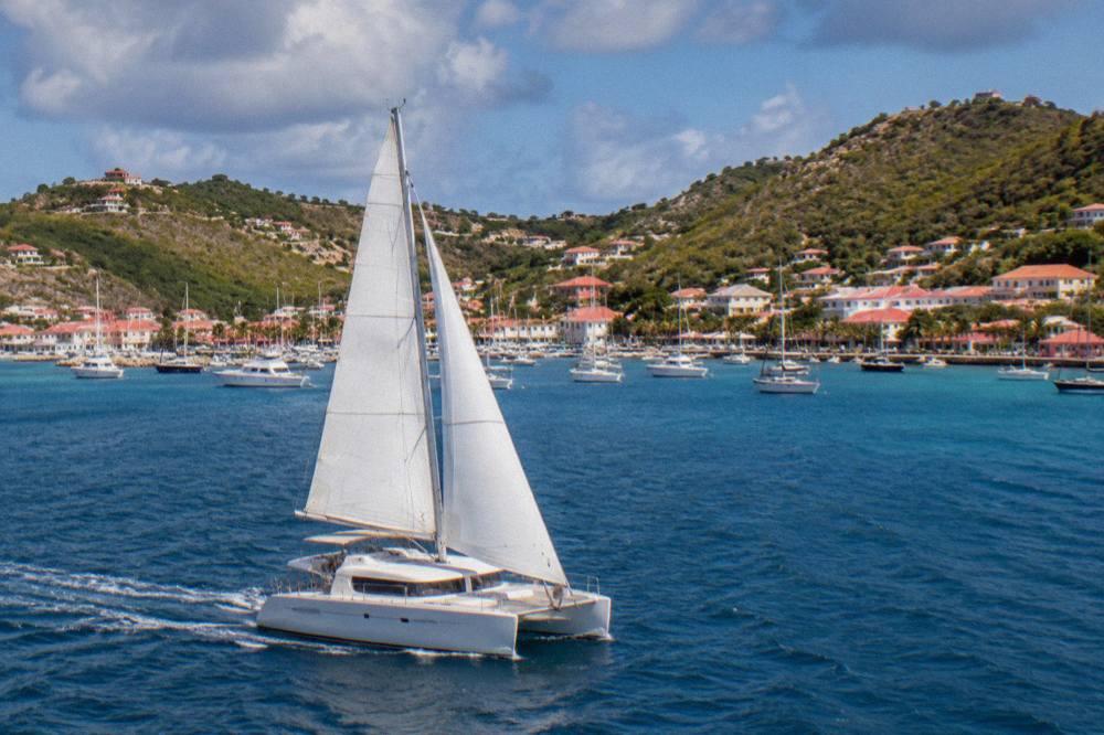 A catamaran under sail on open water between St Martin and St Barts