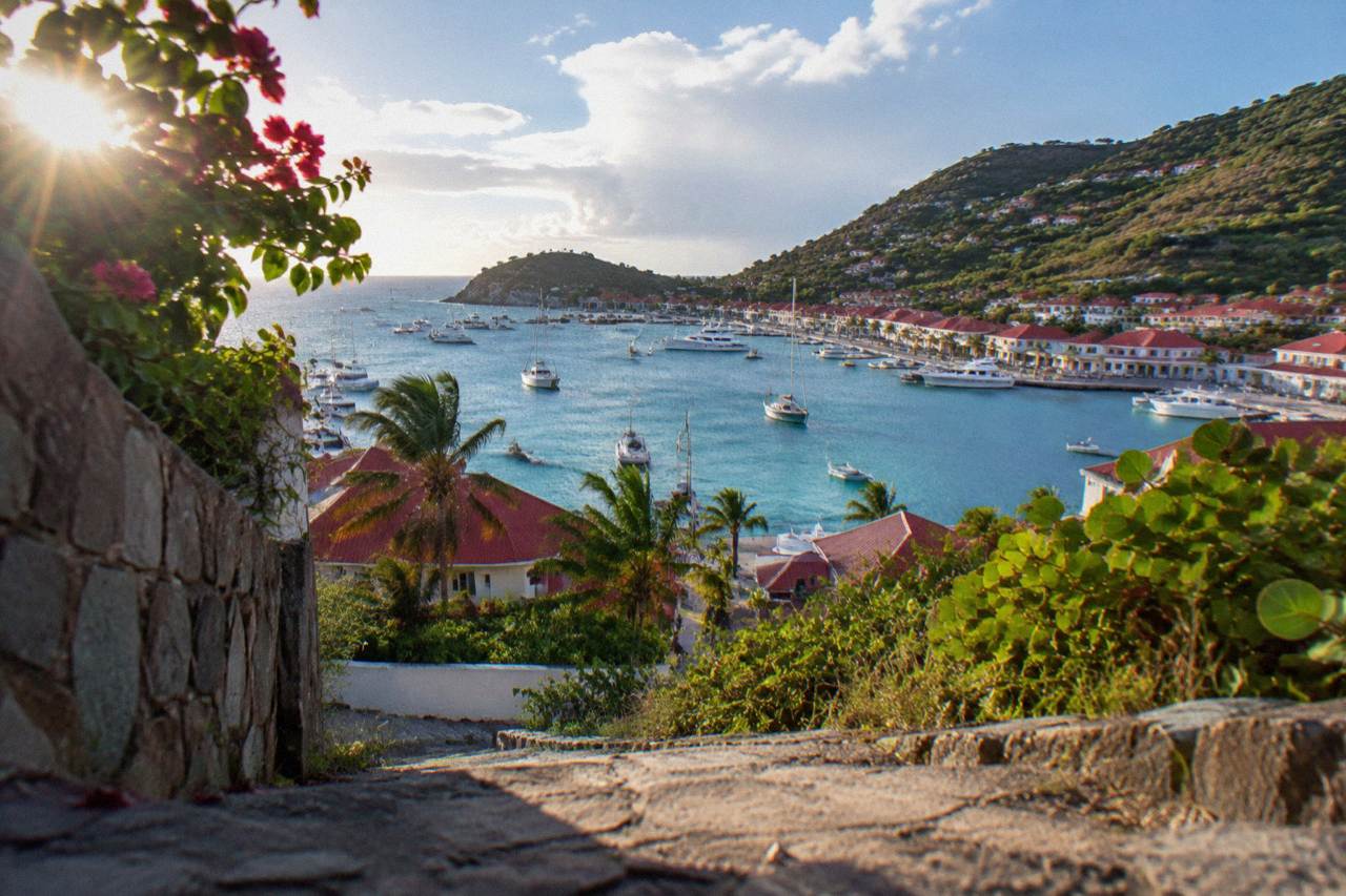 Turquoise water and green hills seen from above a small Caribbean island harbour