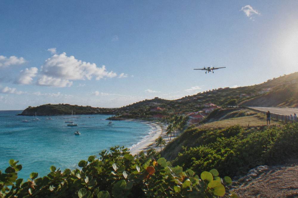 Clear shallow water over pale sand with a wooded headland in the distance