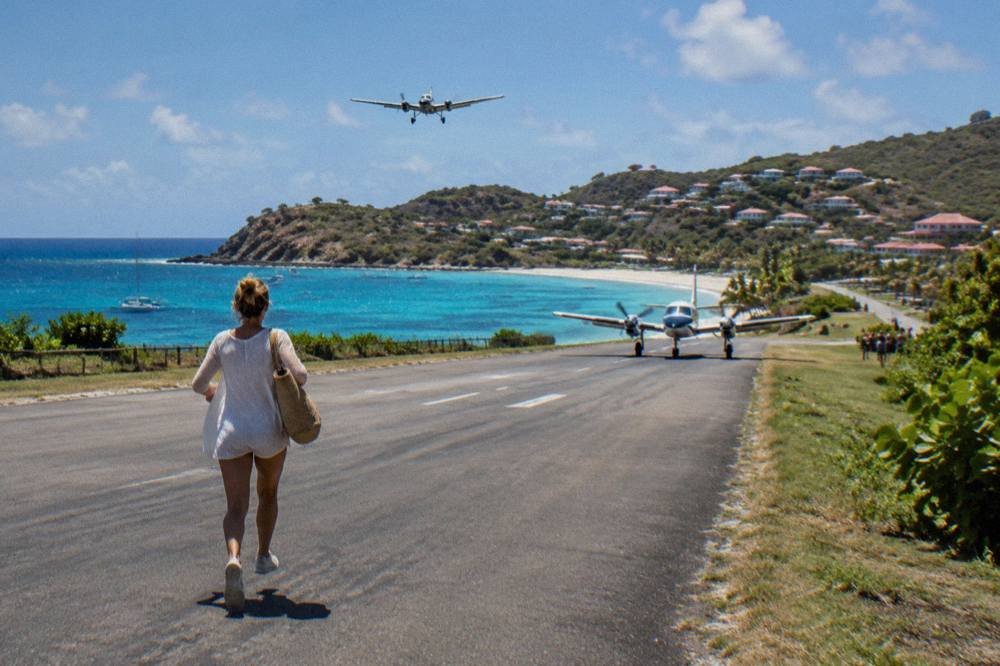 A small turboprop aircraft on the short runway at Gustaf III airport beside the beach at Saint-Jean