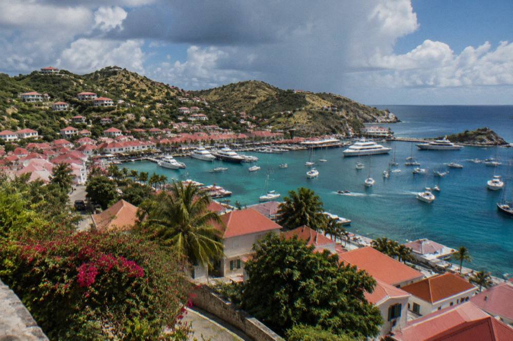 A hillside view over red roofs of Gustavia and boats in the harbor below